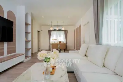 Elegant living room with modern decor and natural light, featuring a cozy seating area and stylish dining space.