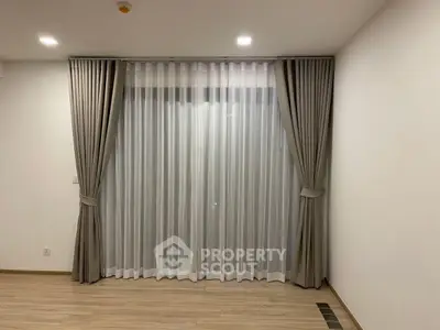 Elegant living room with floor-to-ceiling curtains and modern lighting