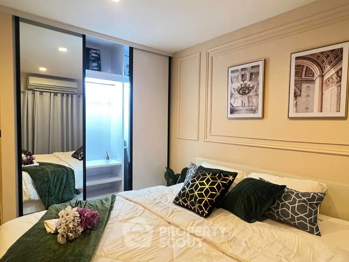 Luxurious bedroom with elegant decor and mirrored wardrobe in modern apartment.
