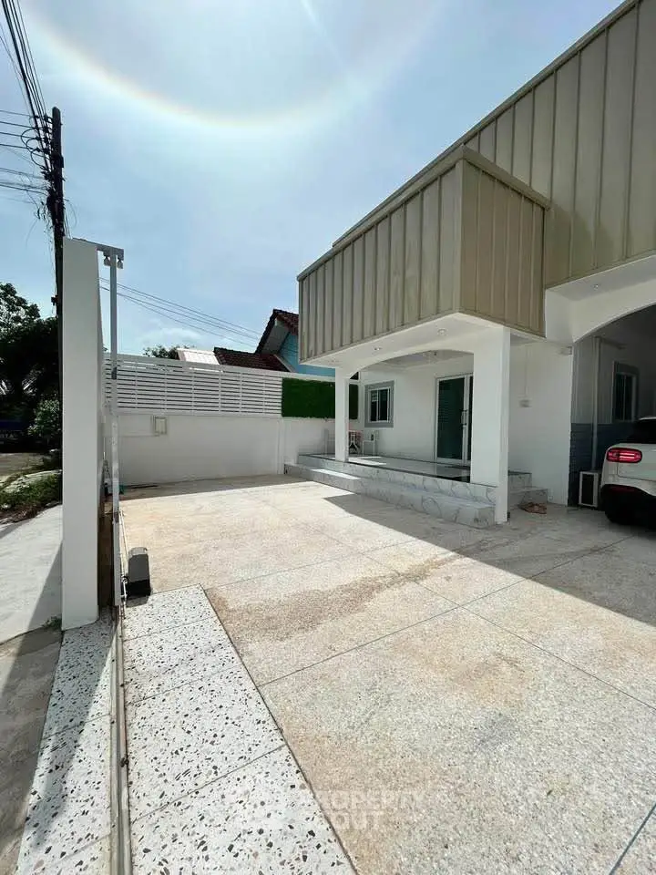 Modern residential exterior with spacious driveway and contemporary design.