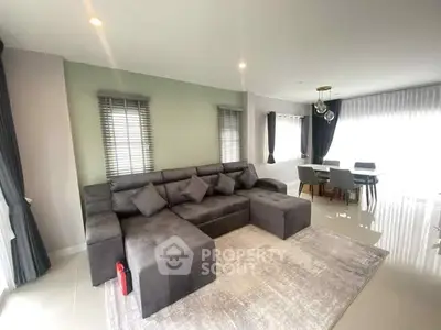 Spacious modern living room with elegant gray sofa and dining area