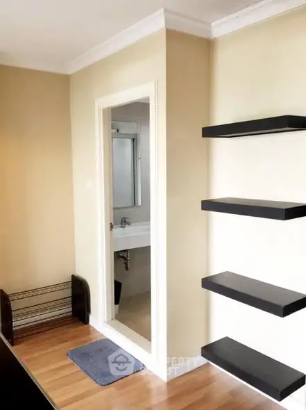 Modern interior with floating shelves and bathroom entrance, ideal for stylish living.