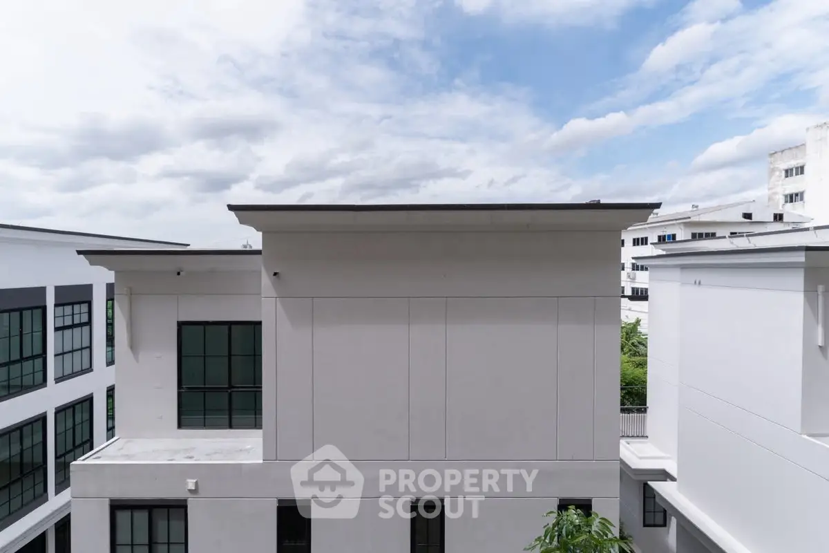 Modern building exterior with sleek design and large windows under a clear blue sky.