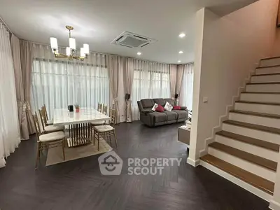 Elegant living room with modern dining area and stylish staircase