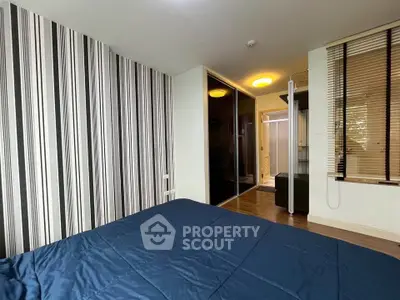 Modern bedroom with stylish striped wallpaper and cozy ambiance