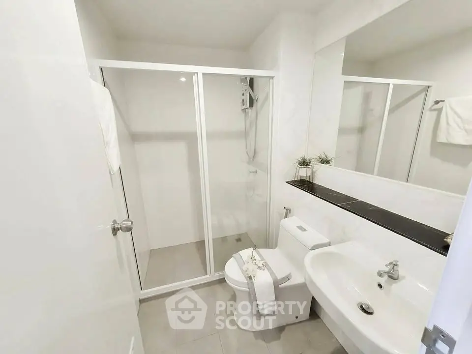 Modern bathroom with glass shower enclosure and sleek fixtures