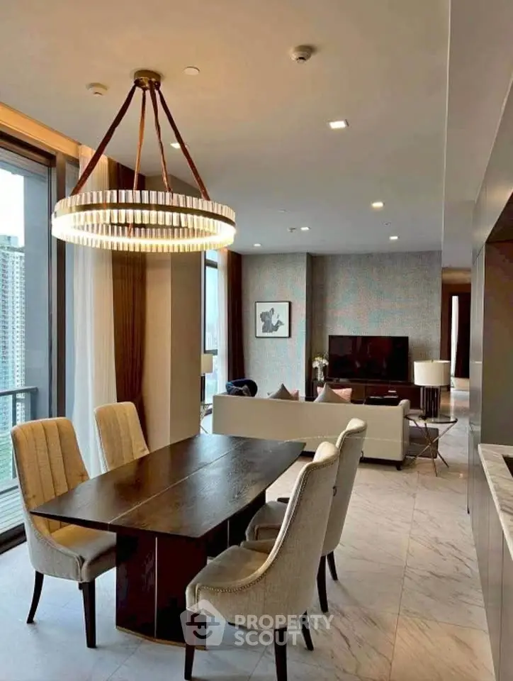 Luxurious open-plan living and dining area with elegant chandelier and city view.