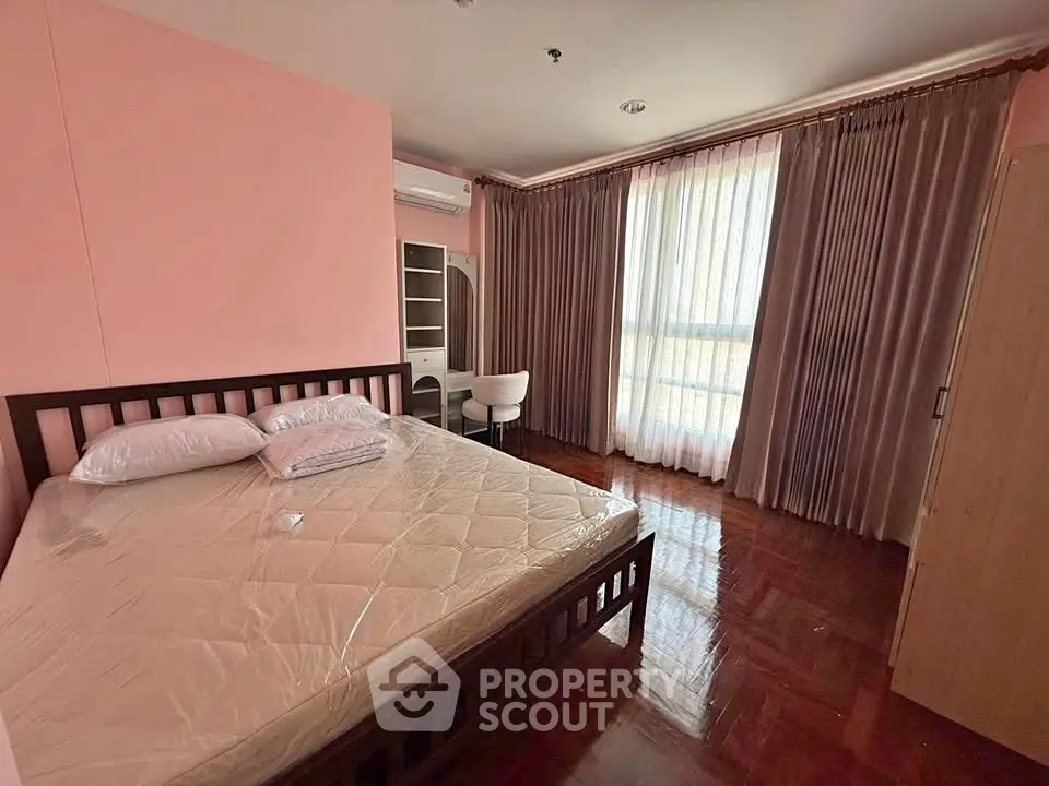 Spacious bedroom with large window and elegant curtains in modern apartment.