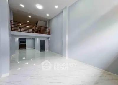 Spacious modern interior with high ceilings and mezzanine, perfect for versatile living or office space.