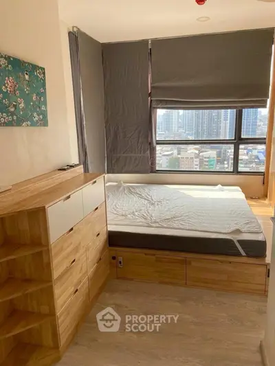 Cozy bedroom with wooden furniture and city view, perfect for urban living.
