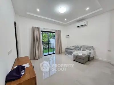 Spacious living room with modern sofa and garden view, perfect for relaxation.