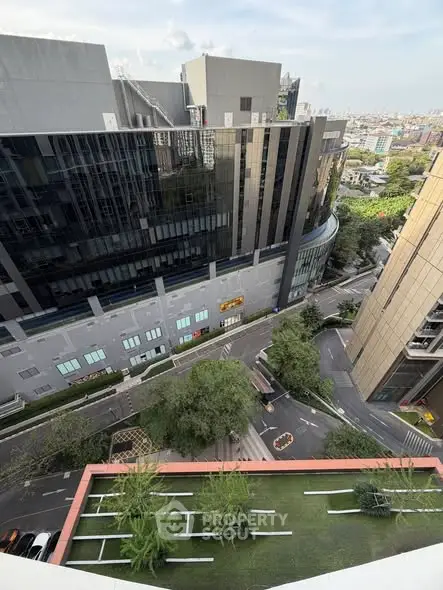 Stunning urban view from high-rise building overlooking modern architecture and lush greenery.