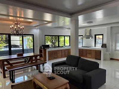 Spacious open-plan living room and kitchen with modern decor and natural light.
