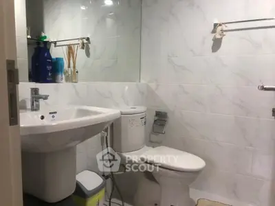 Modern bathroom with sleek fixtures and marble tiles, featuring a clean and minimalist design.