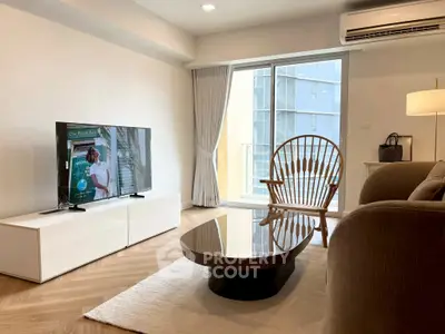 Modern living room with stylish furniture and large window offering natural light.