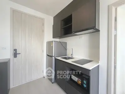 Modern kitchen with sleek cabinetry and compact appliances in a stylish apartment.