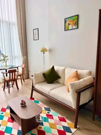 Chic living room with high ceilings, modern furniture, and colorful rug, perfect for stylish urban living.