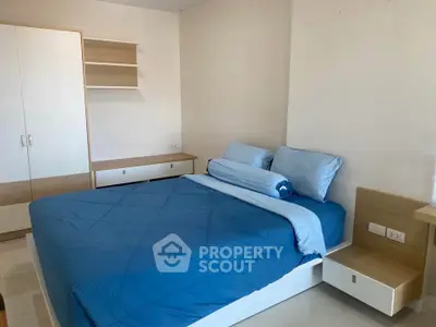 Modern bedroom with blue bedding and built-in storage in a stylish apartment.
