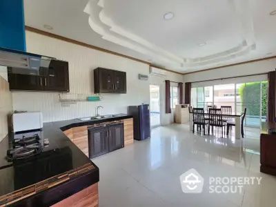 Spacious open-layout kitchen and dining area with modern appliances and large windows.