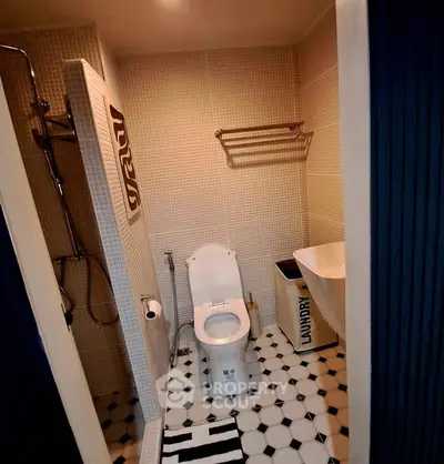 Modern bathroom with stylish tiles, shower, and laundry basket for a chic urban living space.
