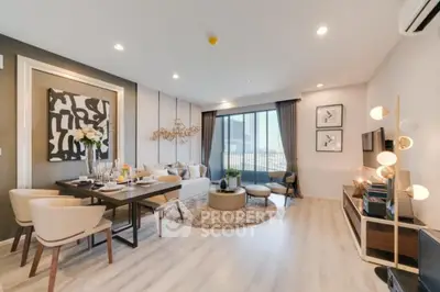 Spacious modern living room with elegant decor and large windows offering city views.