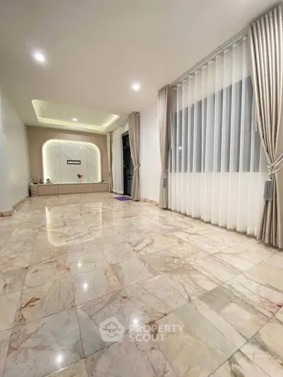 Spacious marble-floored living room with elegant curtains and modern lighting