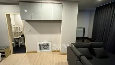 Modern living room with sleek design and cozy sofa, featuring wooden flooring and minimalist decor.