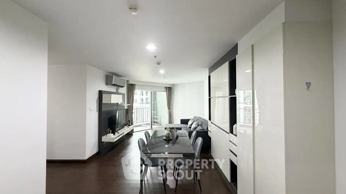 Spacious modern living room with dining area and large windows in a stylish apartment.