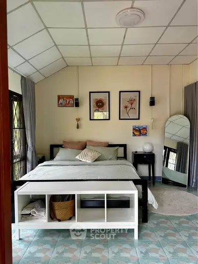 Cozy bedroom with stylish decor and natural light, featuring a comfortable bed and modern furnishings.