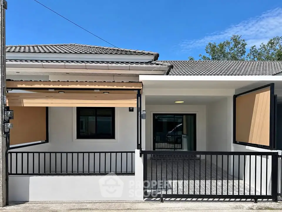 Charming single-story home with modern facade and spacious front porch, perfect for family living.