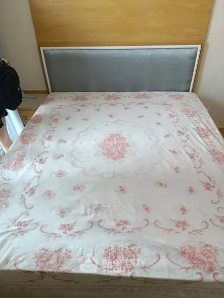 Cozy bedroom with elegant floral bedspread and modern headboard