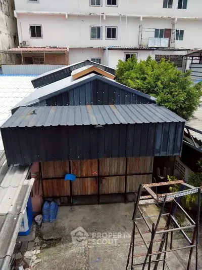 Charming urban property with unique roof design and spacious outdoor area.