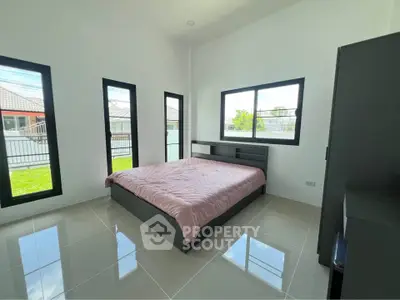 Modern bedroom with large windows and sleek design in a contemporary home.