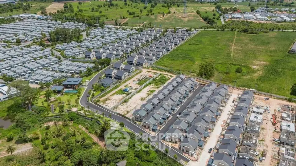 Aerial view of a modern residential housing development with green surroundings.