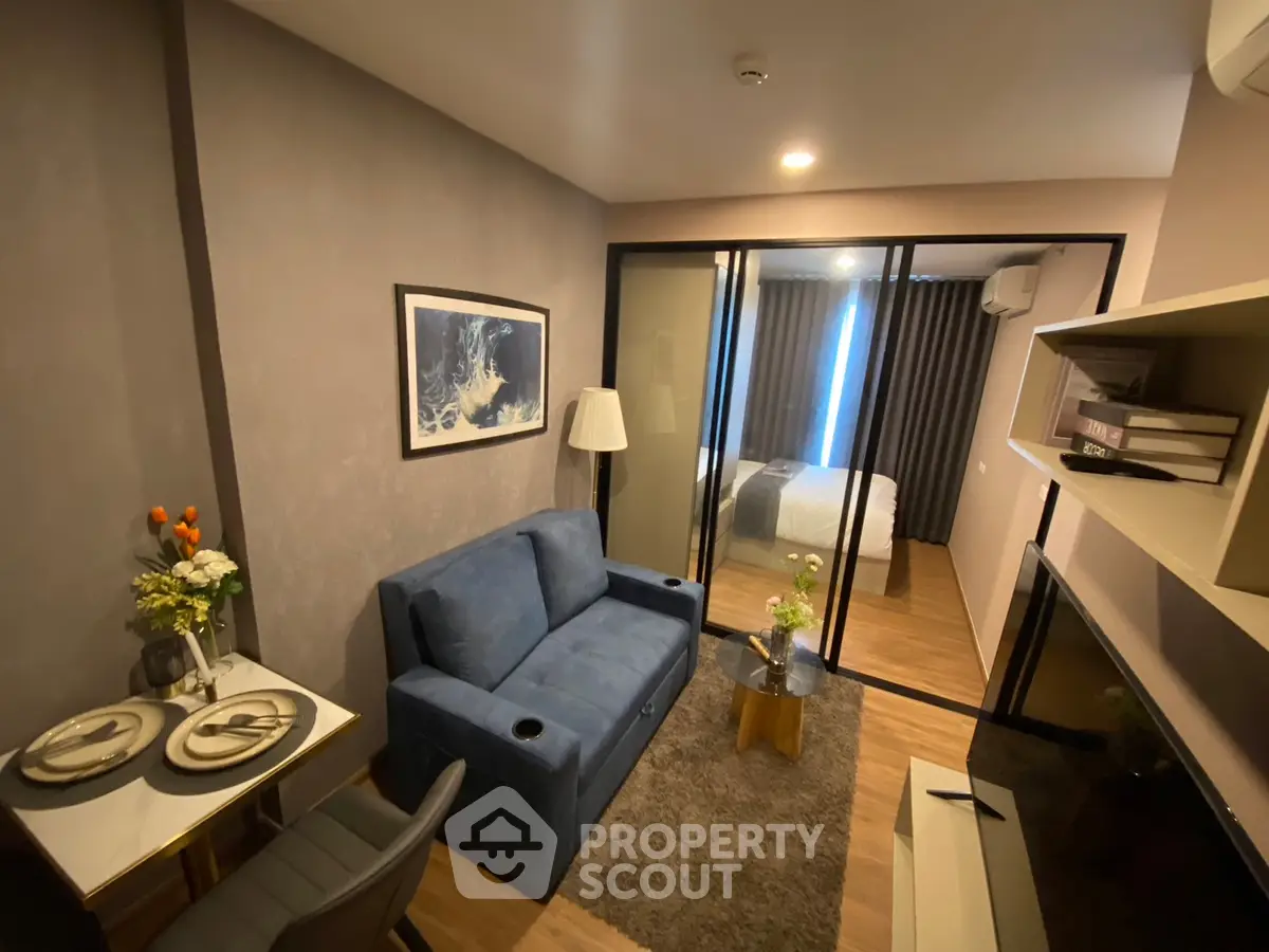 Modern living room with cozy blue sofa and stylish decor in a compact apartment