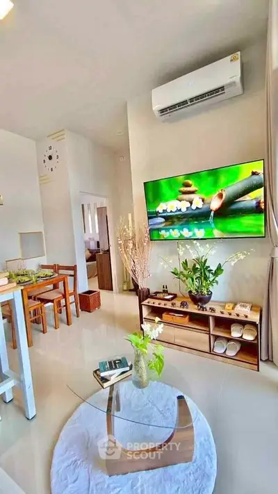 Modern living room with stylish decor and wall-mounted TV in a cozy apartment setting.