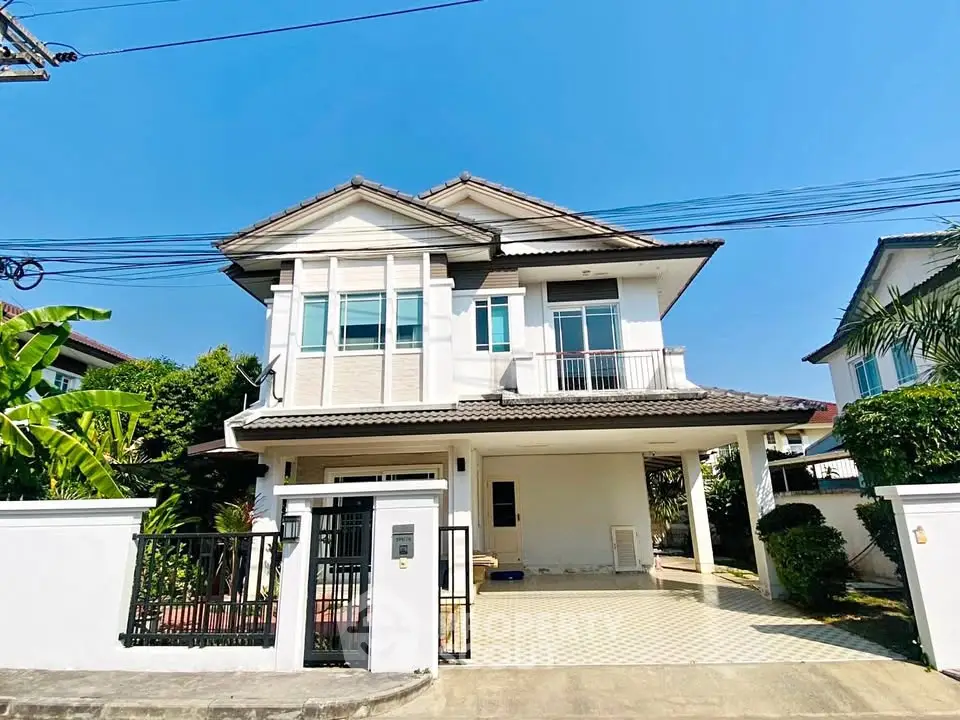 Charming two-story house with spacious driveway and lush greenery in a serene neighborhood.