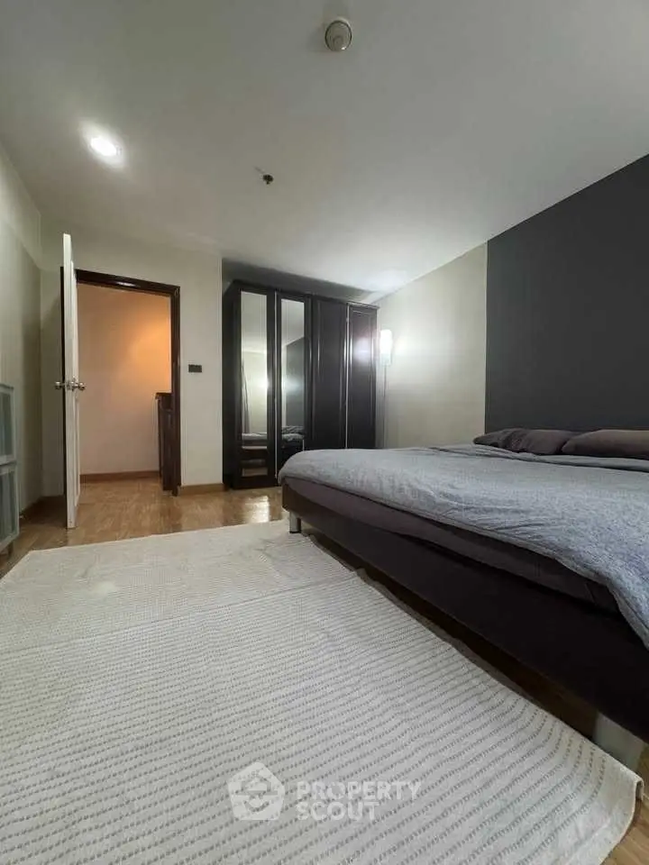 Spacious bedroom with modern decor and ample storage in a stylish apartment.