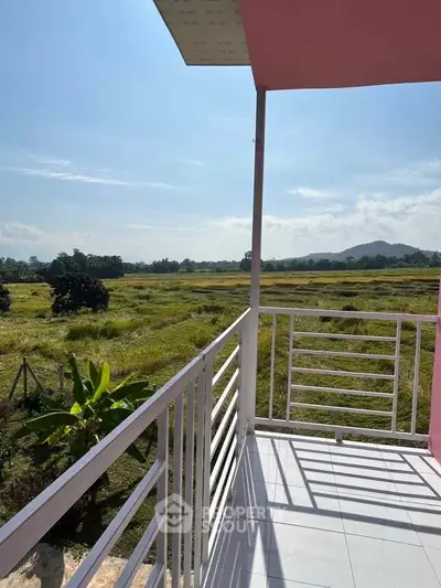Charming balcony with scenic countryside view, perfect for relaxation and enjoying nature's beauty.