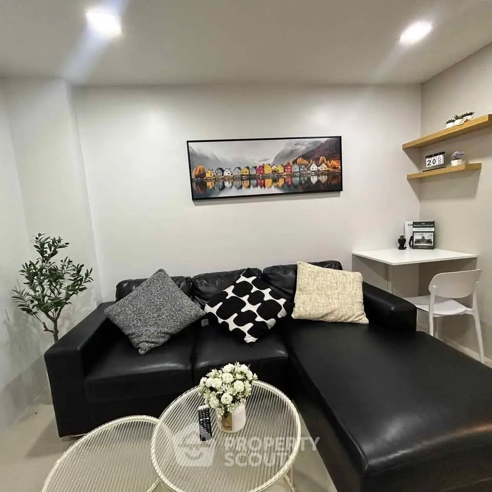 Modern living room with black leather sofa and stylish decor