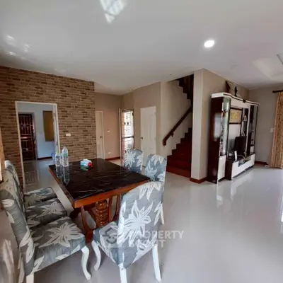 Spacious living room with elegant dining area and modern staircase in a stylish home.
