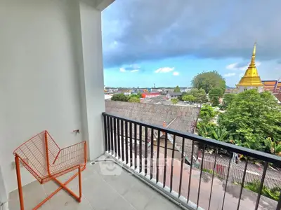 Stunning balcony view with modern chair overlooking cityscape and temple