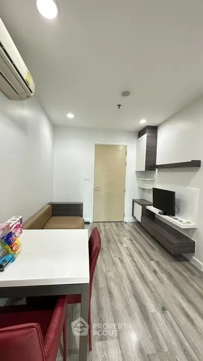 Modern living room with sleek furniture and wood flooring in a stylish apartment.