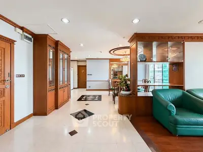Spacious living room with elegant wooden decor and green sofa in a luxury apartment.