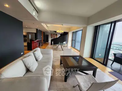 Luxurious open-plan living room with stunning city views and modern furnishings in a high-rise apartment.