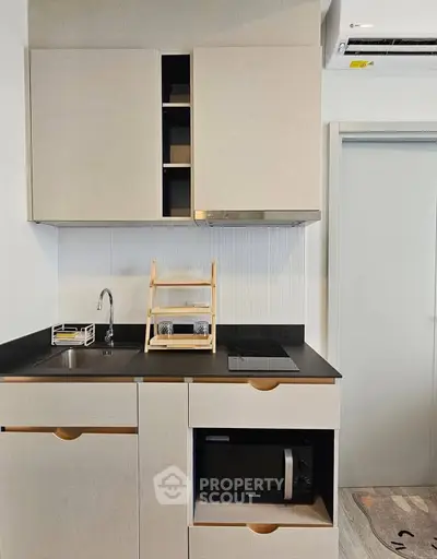 Modern compact kitchen with sleek cabinetry and built-in appliances, perfect for urban living.