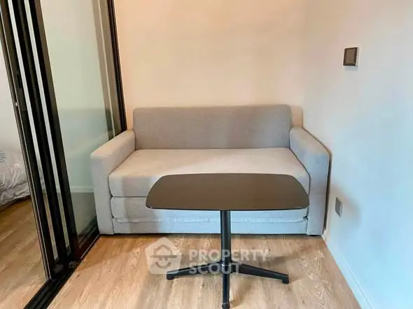Cozy compact living room with modern sofa and sleek table, perfect for small spaces.