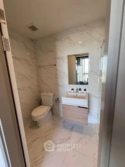 Modern bathroom with marble tiles and sleek fixtures in a contemporary home.