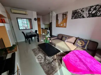 Modern living room with stylish decor and natural light, featuring a cozy sofa and dining area.
