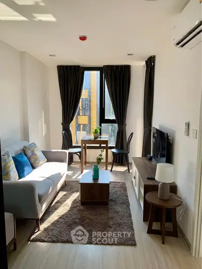 Modern living room with natural light, stylish furniture, and cozy ambiance in a contemporary apartment.